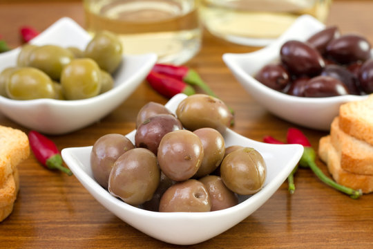 olives with toasts and glass of white wine