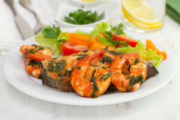 Fototapeta premium fish with shrimps and salad on the plate and glass of water