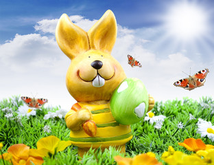 Osterhase auf einer Wiese mit Ostereiern und Sonne