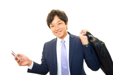 携帯電話を持ち微笑むビジネスマン