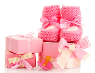 pink baby boots, pacifier and gifts isolated on white