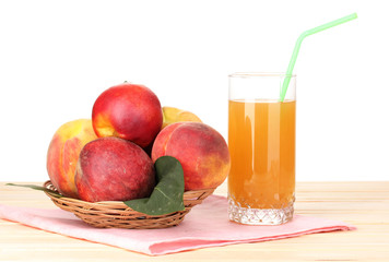 Ripe peaches and juice on wooden table on white background