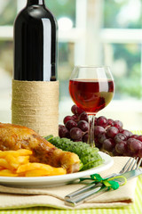 Roast chicken with french fries and cucumbers, glass of wine