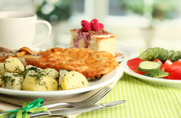 Roast chicken cutlet with boiled potatoes and cucumbers, cup of