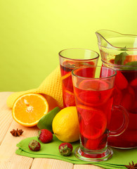 sangria in jar and glasses with fruits,
