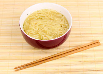 asian noodles in bowl on bamboo mat