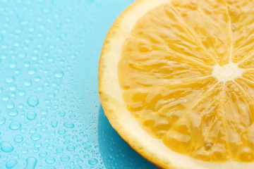 Slice of lime with drop on blue background