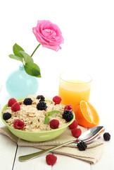 tasty oatmeal with berries and glass of juice,