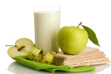 Glass of kefir, green apples, crispbreads and measuring tape