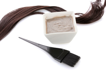 Bowl with hair dye and black brush on white background close-up