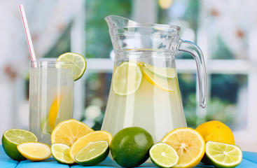 Citrus lemonade in pitcher and glass of citrus around