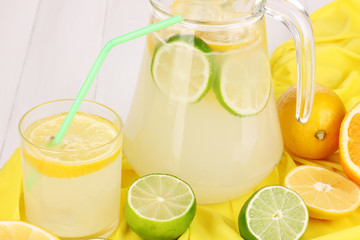 Citrus lemonade in glass and pitcher of citrus around