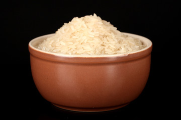 White polished rice in brown bowl isolated on black