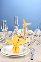 Table setting in white and yellow tones on color  background
