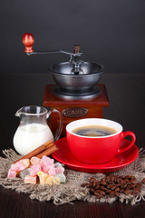 Red cup of coffee with rahat delight, milk and coffee mill
