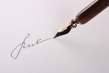 Closeup of signature (fake, not real) and ink pen, isolated
