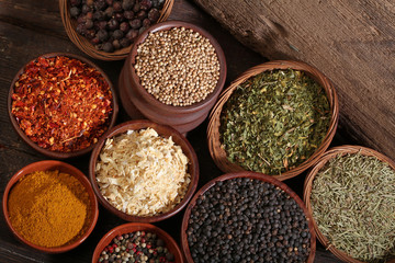 Different bowls of spices over a wooden background