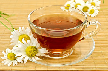 Herbal tea with camomiles on a bamboo