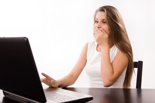 Astonished girl behind a laptop
