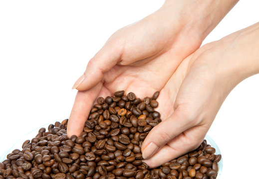coffee beans pouring out of cupped woman hands