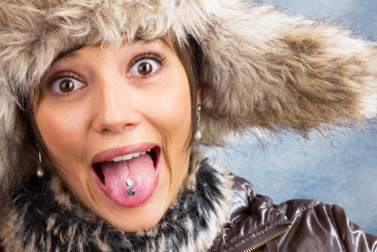Funny pretty woman with fur hat joking, winter portrait