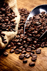 Kaffeetasse und geröstete Bohnen auf Holztisch - Kaffeegenuss