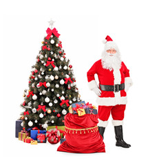 Fototapeta premium Santa Claus standing next to a Christmas tree