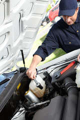 Car mechanic working in auto repair service.