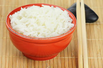 Steamed basmati rice in a red bowl with chopsticks
