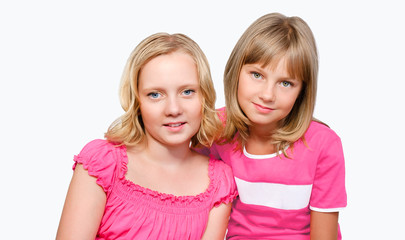 two smiling preteen girls isolated over white background
