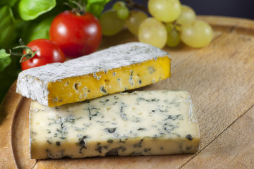 Cheese on cutting board closeup with basil