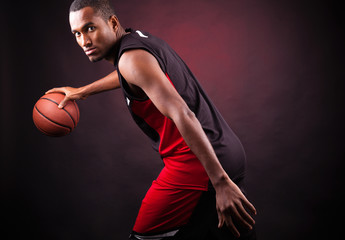 Portrait of a young male basketball player against black backgr