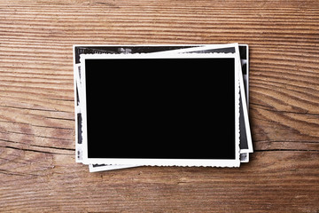 Stack of old photos on wooden background