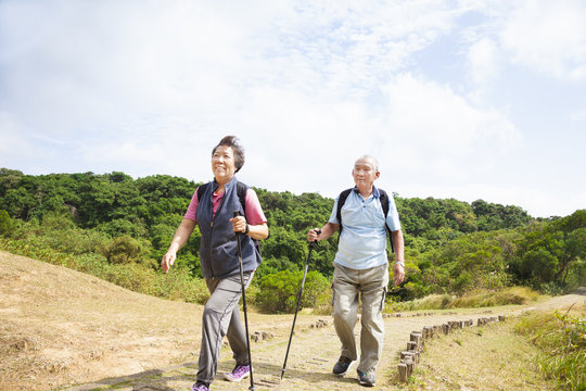 happy asian senior couple hiking