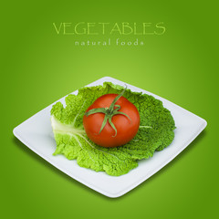 Savoy cabbage and tomato in plate on green background