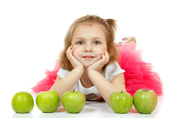 Fototapeta premium Cute little girl lying and playng with apples.