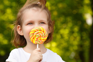 happy little girl with sweet candy nature outdoor