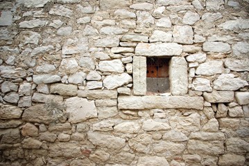 Fototapeta na wymiar Kamienny mur z małym oknie tle tekstury