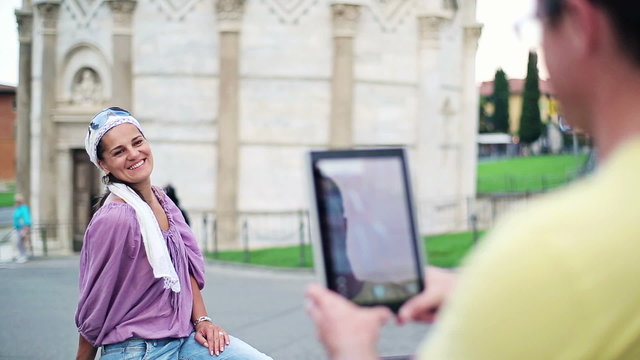 Couple taking photo with tablet by Leaning Tower of Pisa