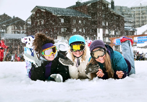 Young girls are snowboarders in mountains