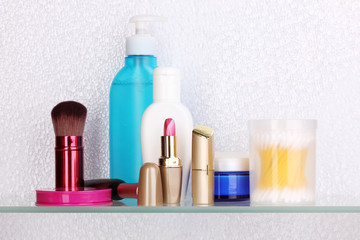 Shelf with cosmetics and toiletries in bathroom