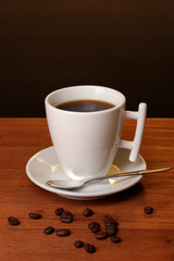 Coffee cup on wooden table on brown background