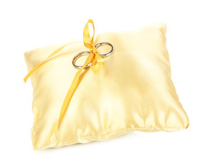 Fototapeta na wymiar Wedding rings on satin pillow isolated on white