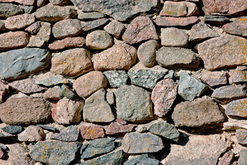 Fragment of a stone wall with colorful stones