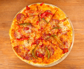 Tasty pepperoni pizza on wooden board on wooden background