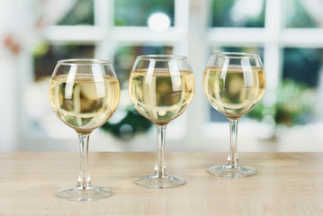 White wine in glass on window background