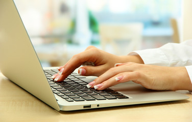female hands writing on laptot, close up