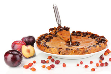 Tasty pie on plate with plums isolated on white