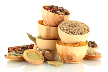wooden bowls and spoons with spices isolated on white
