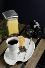 China fondue set, camera and orange slice on wooden table